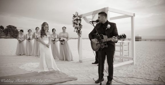 Groom singing to bride on the beach